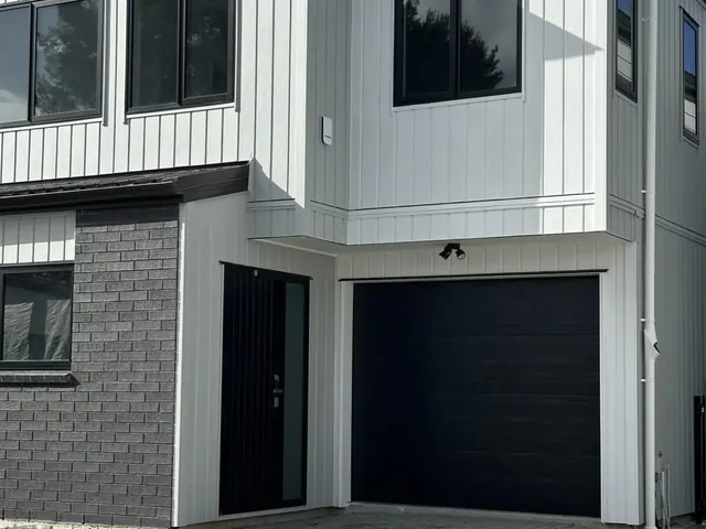 Exterior house painting and cladding finish in progress on an Auckland property