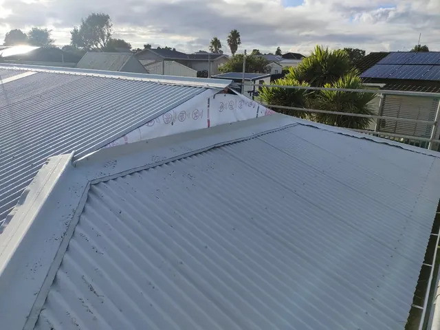 Roof painting and protective coating on a metal roof in progress on an Auckland property